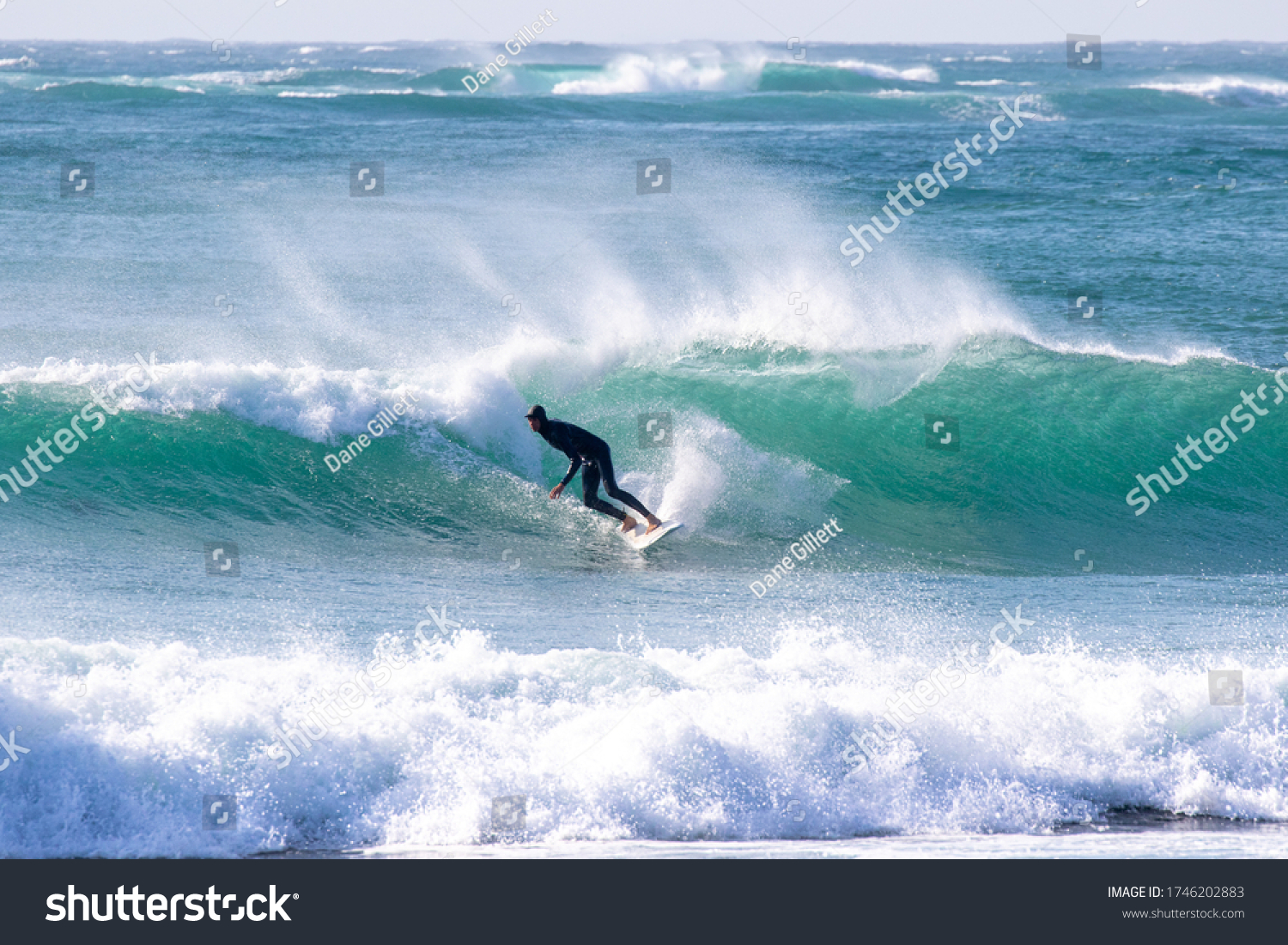 Japan surfing sometimes during a typhoon there are many waves in Japan especially in Hebara Katsuura Chiba. Westerner surfs large waves. Sunrise & at the beach with a surfer & his surf board.