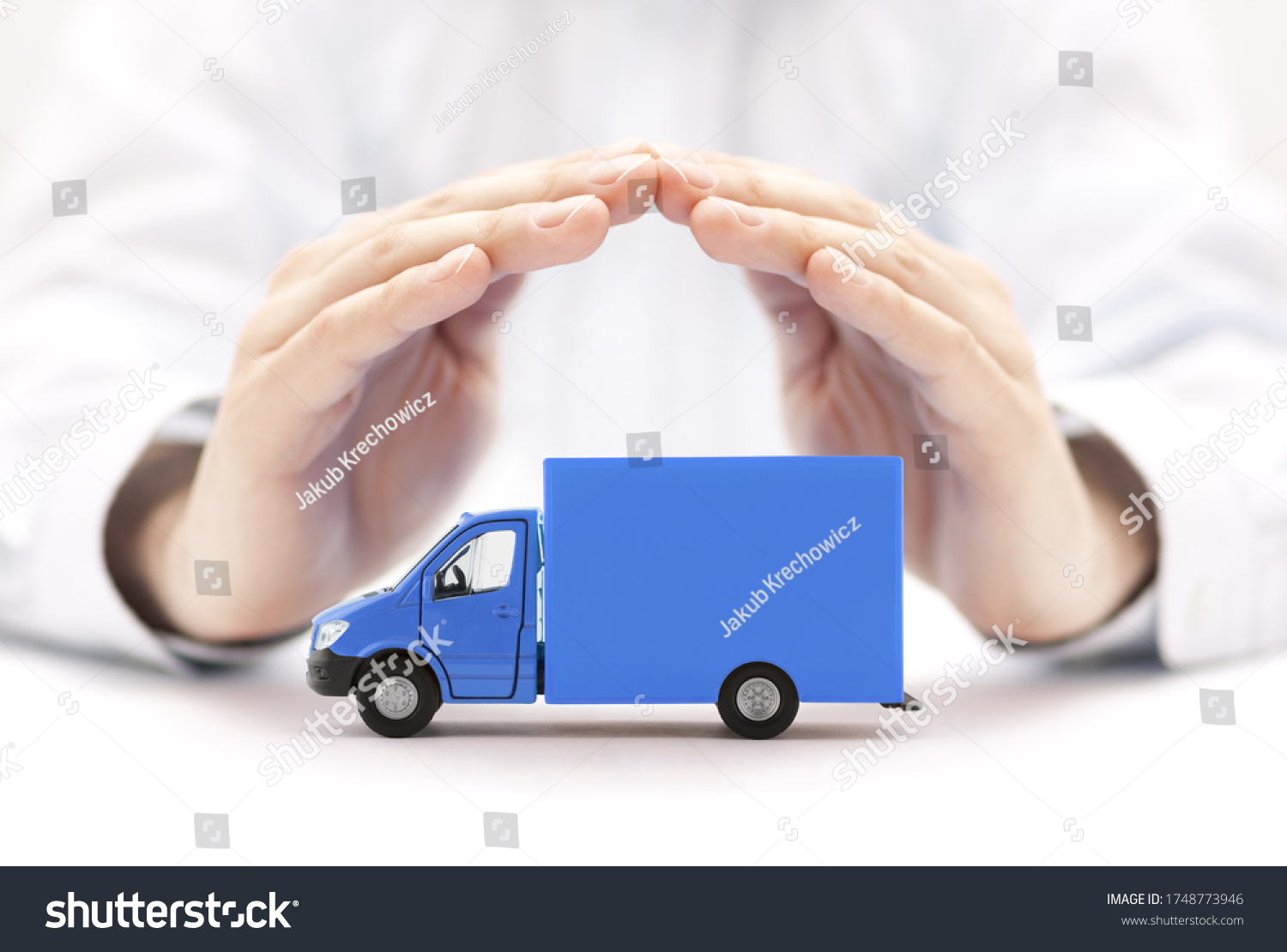 Blue cargo delivery truck protected by hands