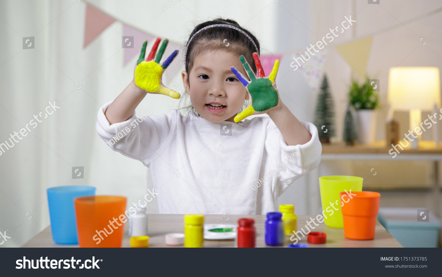 Kid's creativity  Child little asian girl hands painted in colorful paints in the class room at home  Educational concept for school