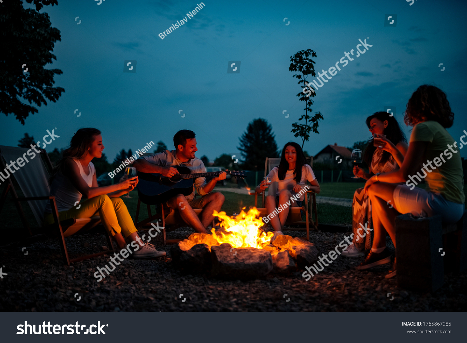 Playing guitar and singing around the bonfire at night.