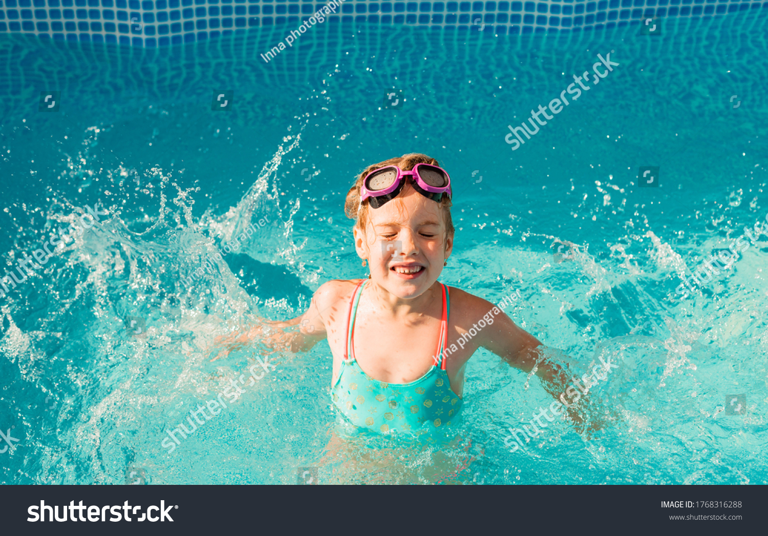 Little happy girl swims in the pool. summer holidays. girl in a swimsuit and swimming glasses.