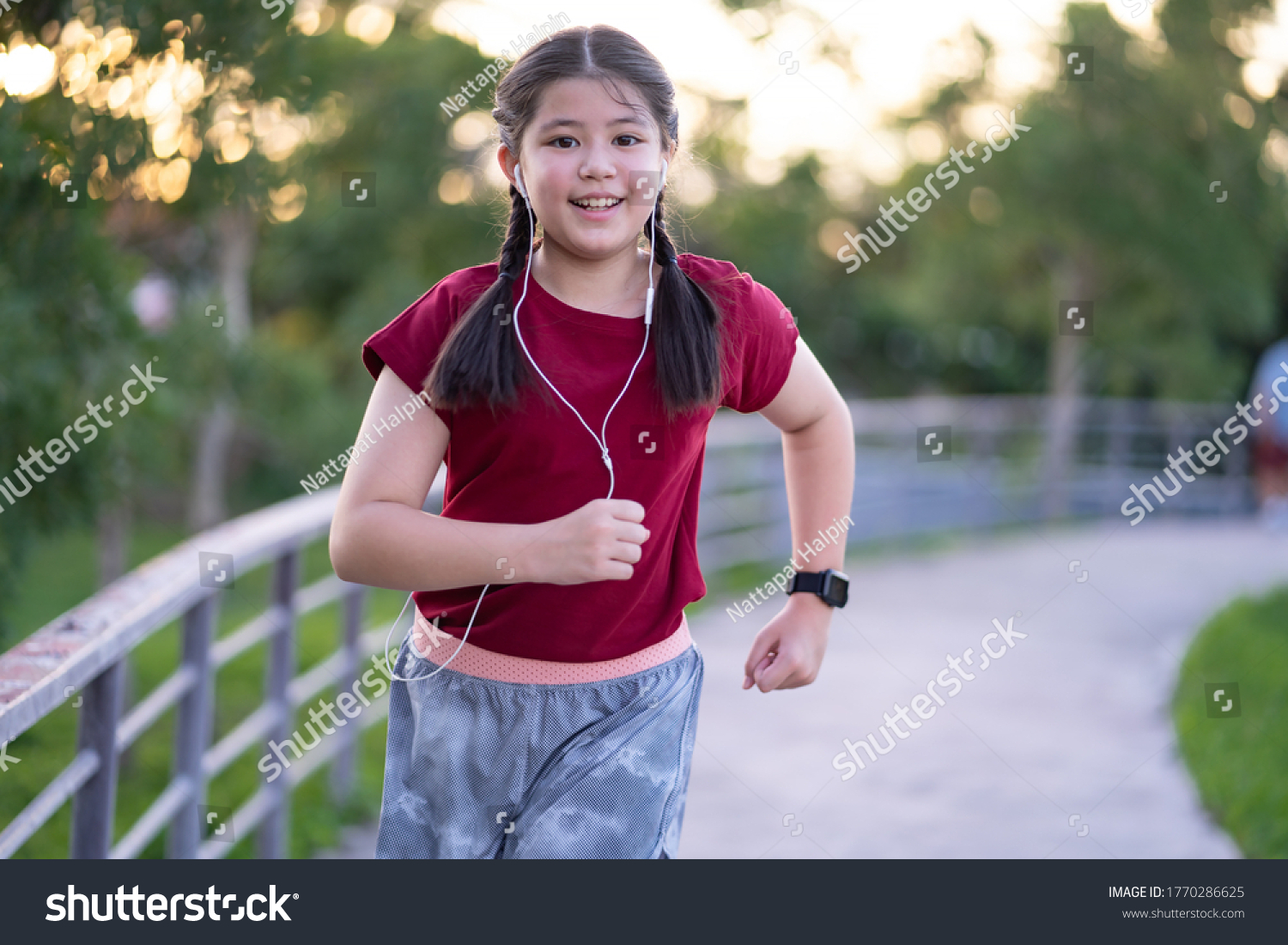 Pre Teen Asian Girl Exercising Outdoors at Sunset Running towards Camera Energetically