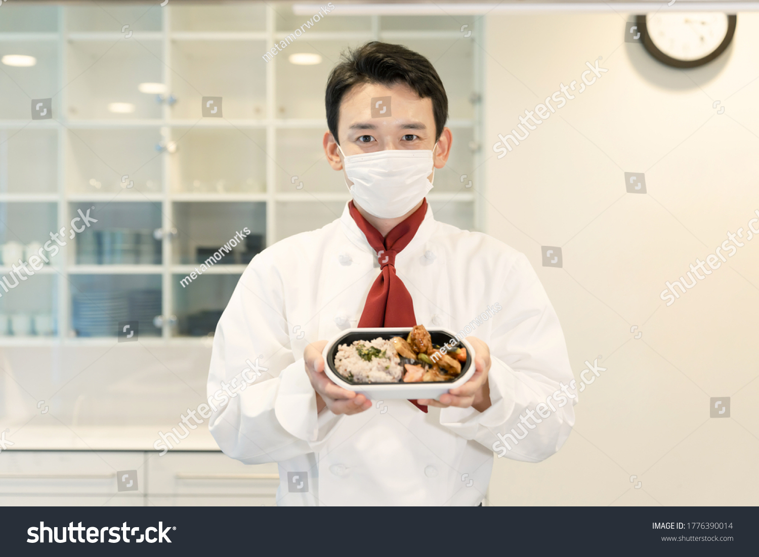 Asian cook in showing lunch box the kitchen. Restaurant. Lunch vendor.