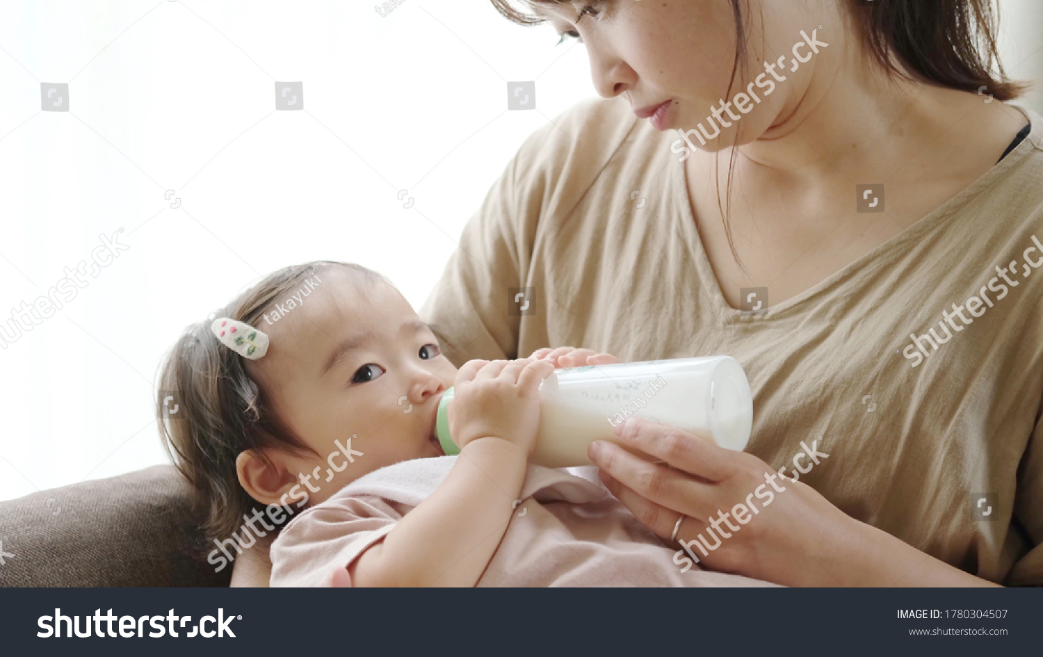 asian baby drinking milk at living room