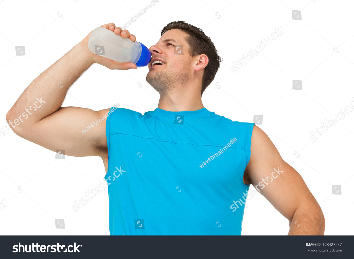 Smiling young man drinking water over white background