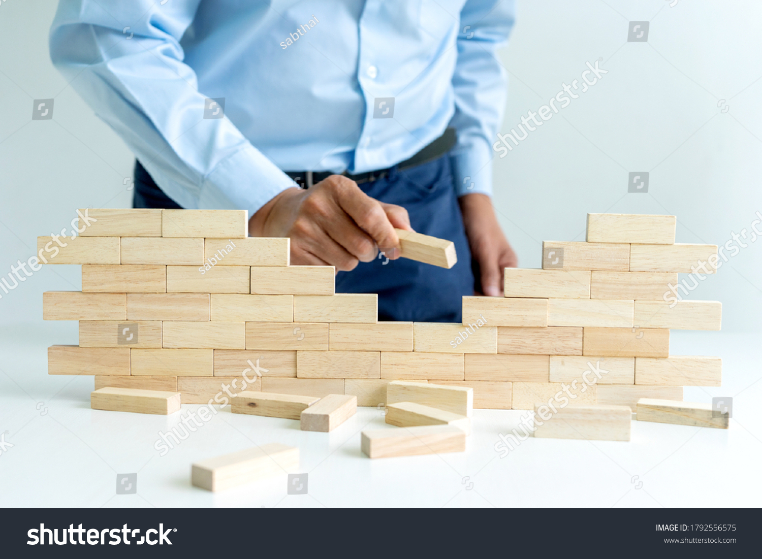 Businessman use wood brick to make wall block it for idea for make business plan image.