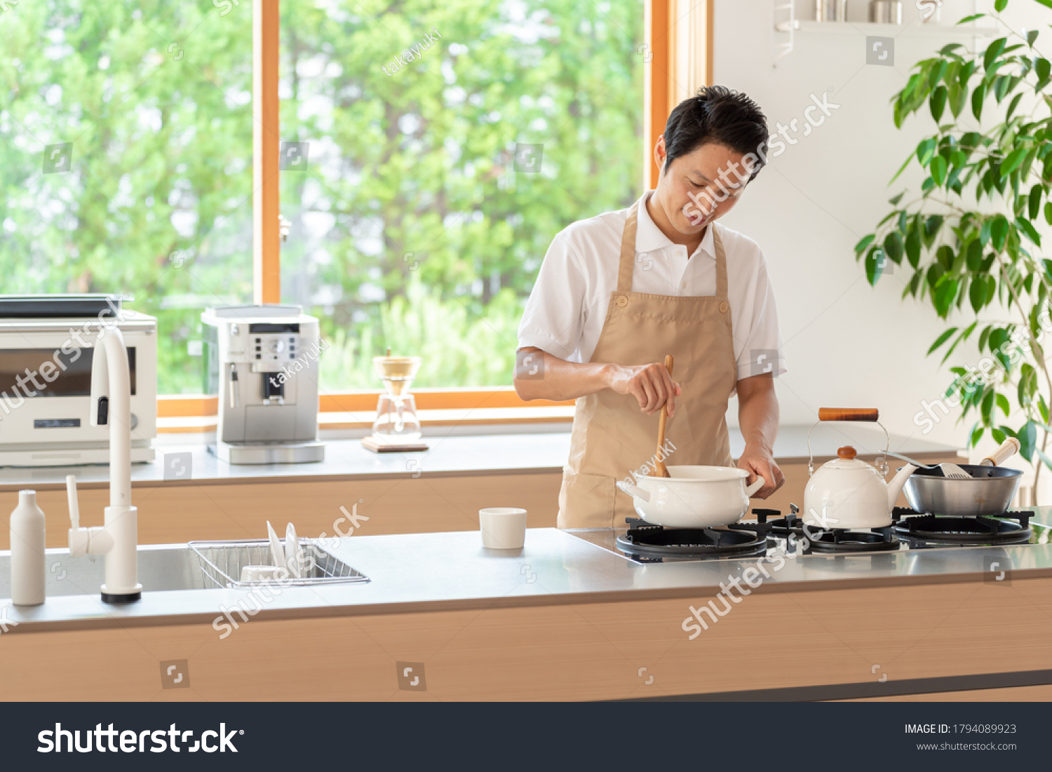 young asian man cooking at kitchen