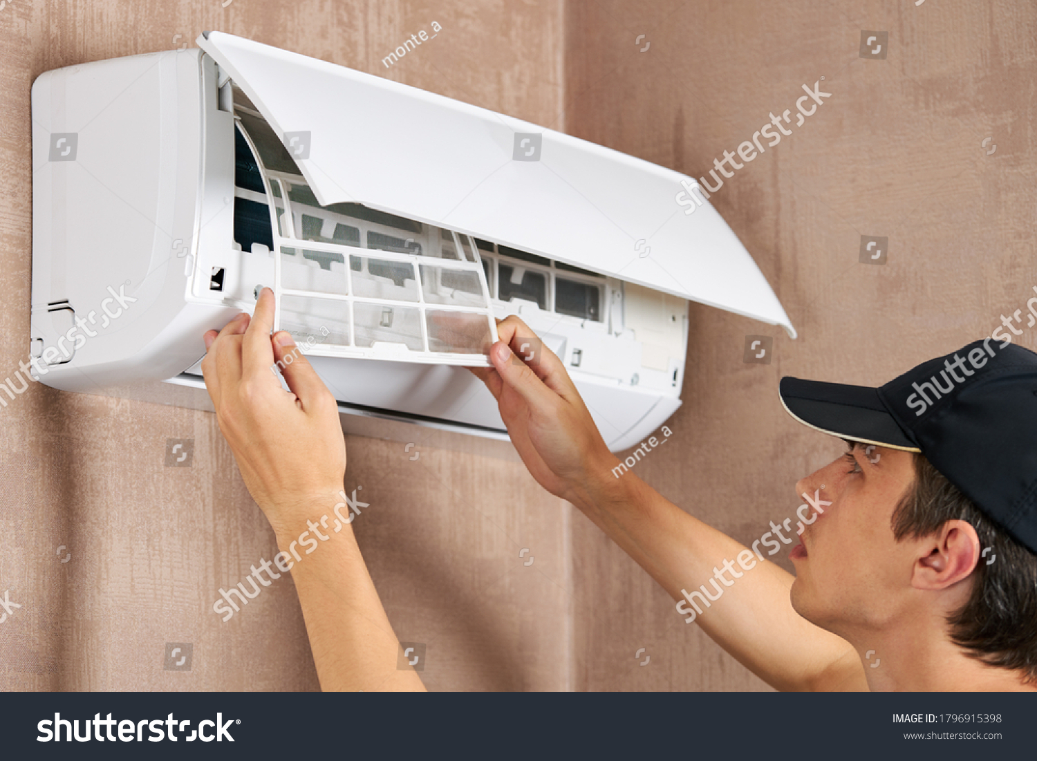 caucasian male technician service worker cleaning air conditioner indoors. diy maintenance concept.