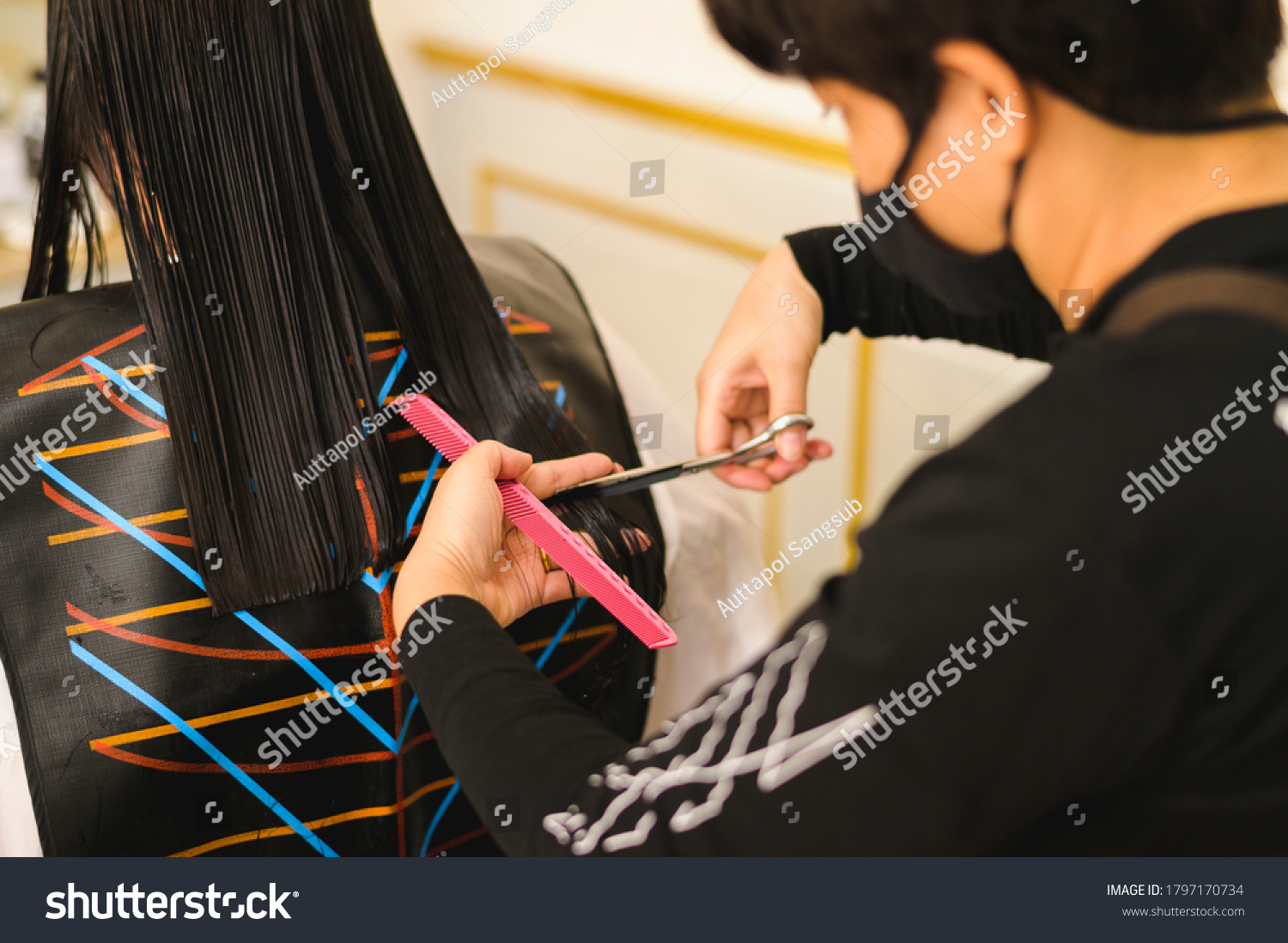 hairdresser giving a new haircut to Asia women customer at salon Beautiful cute young plus size female with loose dark hair enjoying