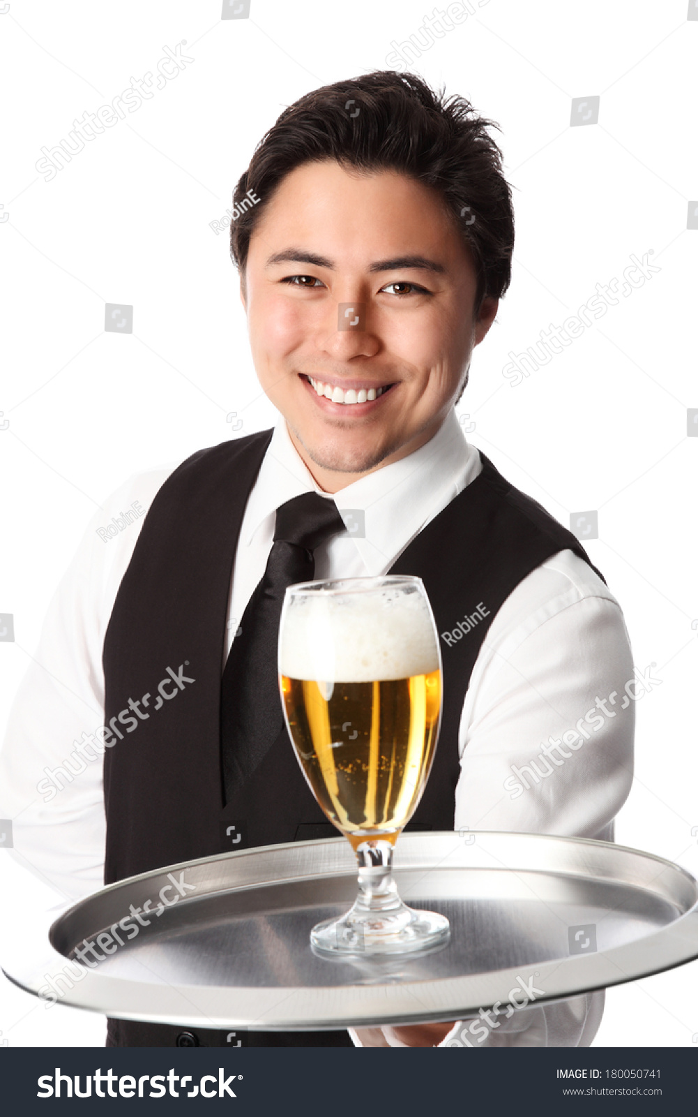 Young attractive waiter wearing a white shirt and black vest serving a nice cold beer. White background.