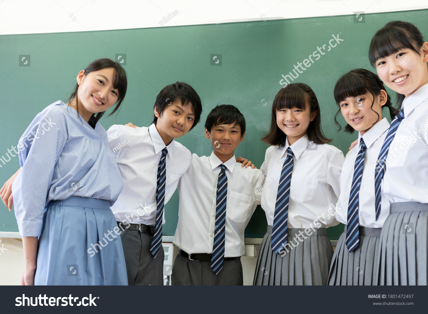 Junior high school students and teachers lined up in front of the blackboard