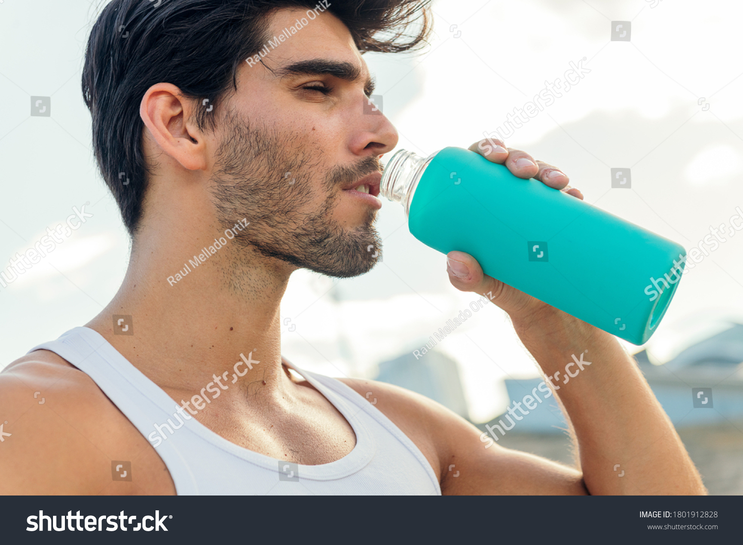 portrait of a handsome sportsman drinking water from a bottle in a break from his training concept of urban sport and healthy lifestyle copy space for text