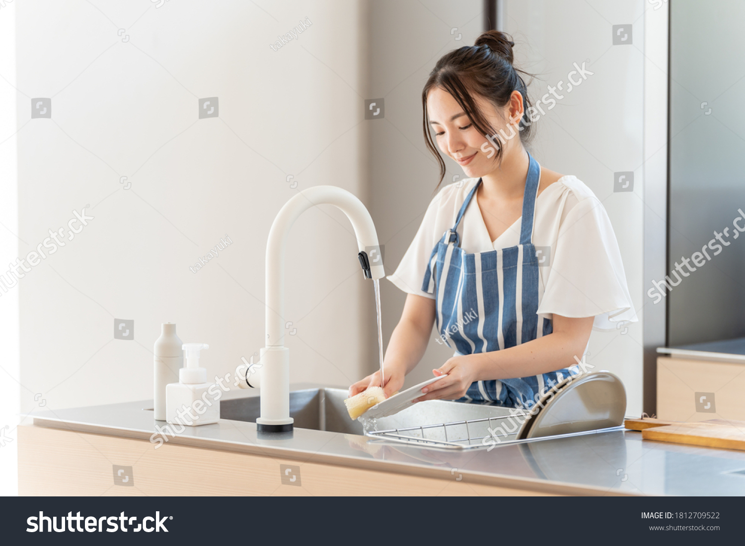 portrait of attractive asian woman washing dish at kitchen