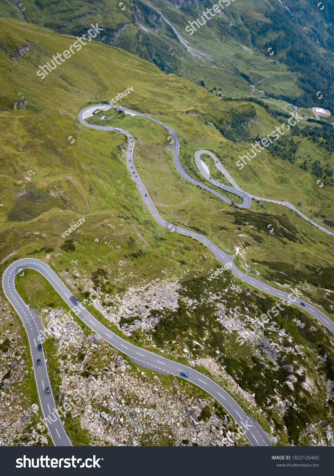 aerial view of serpentine road with green grass in austrian alps