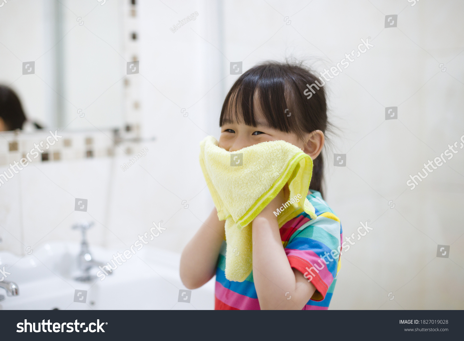 young girl washing face by herself  in bathroom 