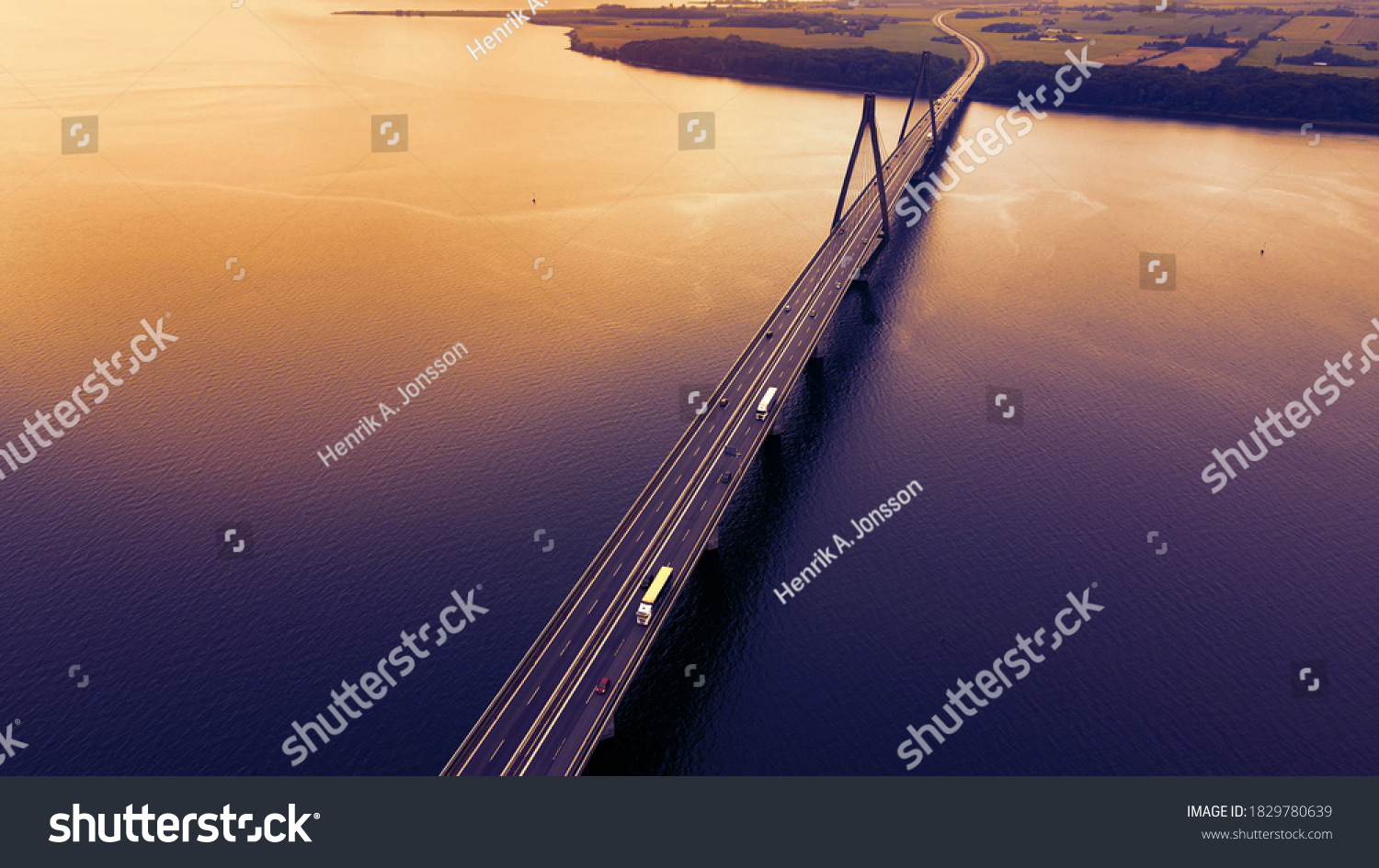 Bridge spanning over a bay with traffic passing in the evening light. Aerial view.