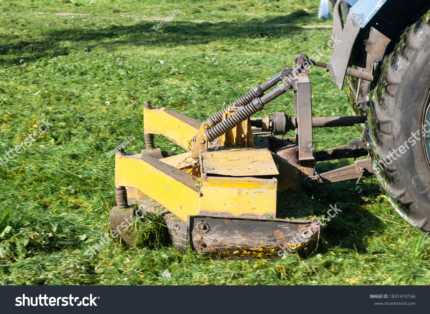 close up of tractor mows the grass on the lawn in the city yard