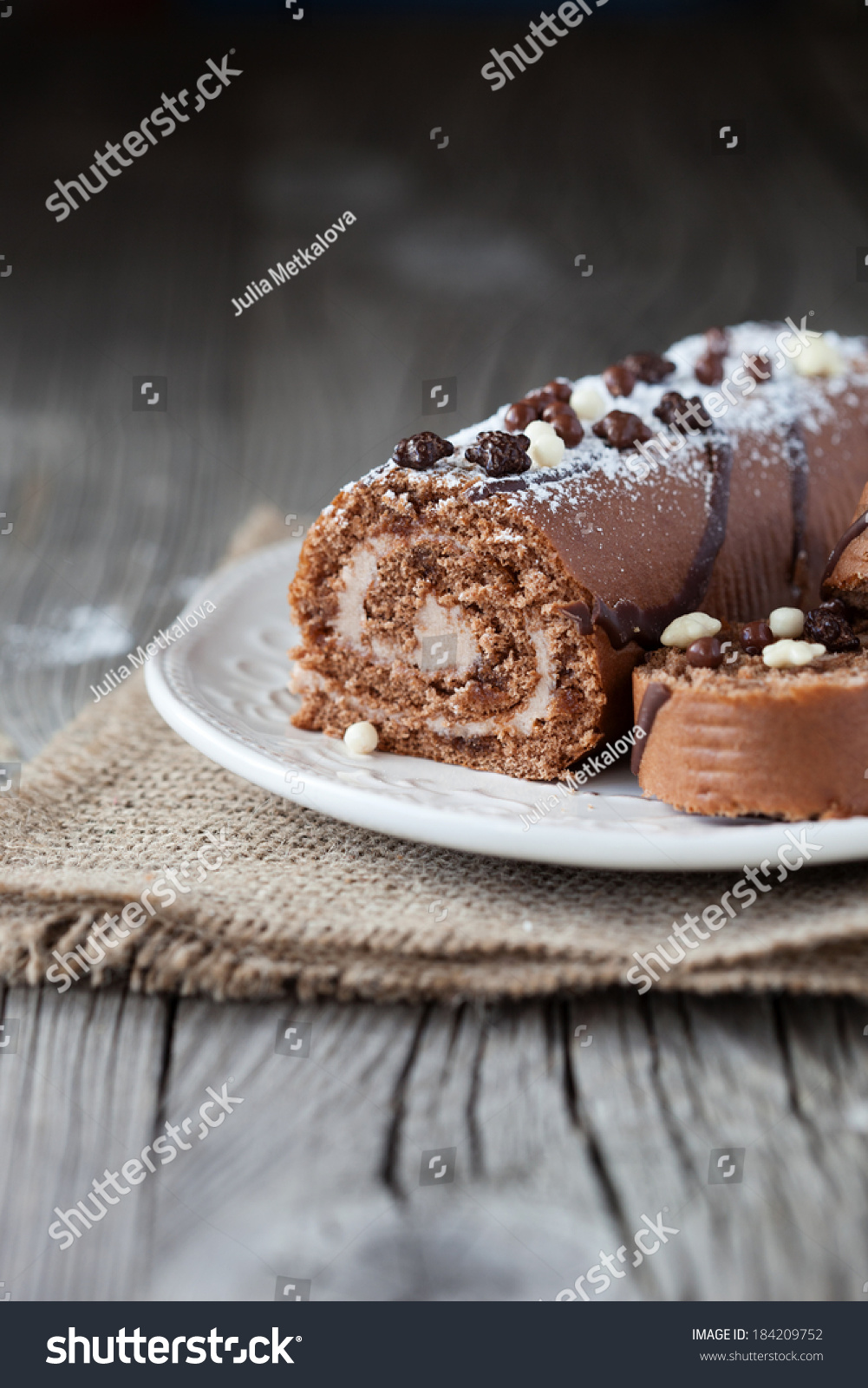 Chocolate cake roll with coffee cream on a wooden background  selective focus