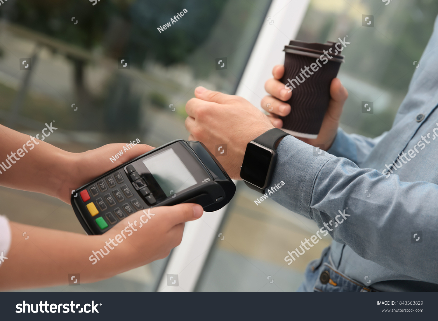 Man using smart watch for contactless payment via terminal in cafe  closeup