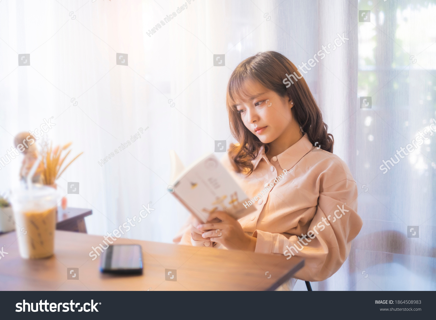 Beautiful Asian girl relaxing studying reading book casual free time weekend at café drinking coffee social distancing feeling sad loneliness bored upset tired sleepy anxious sitting chill careless