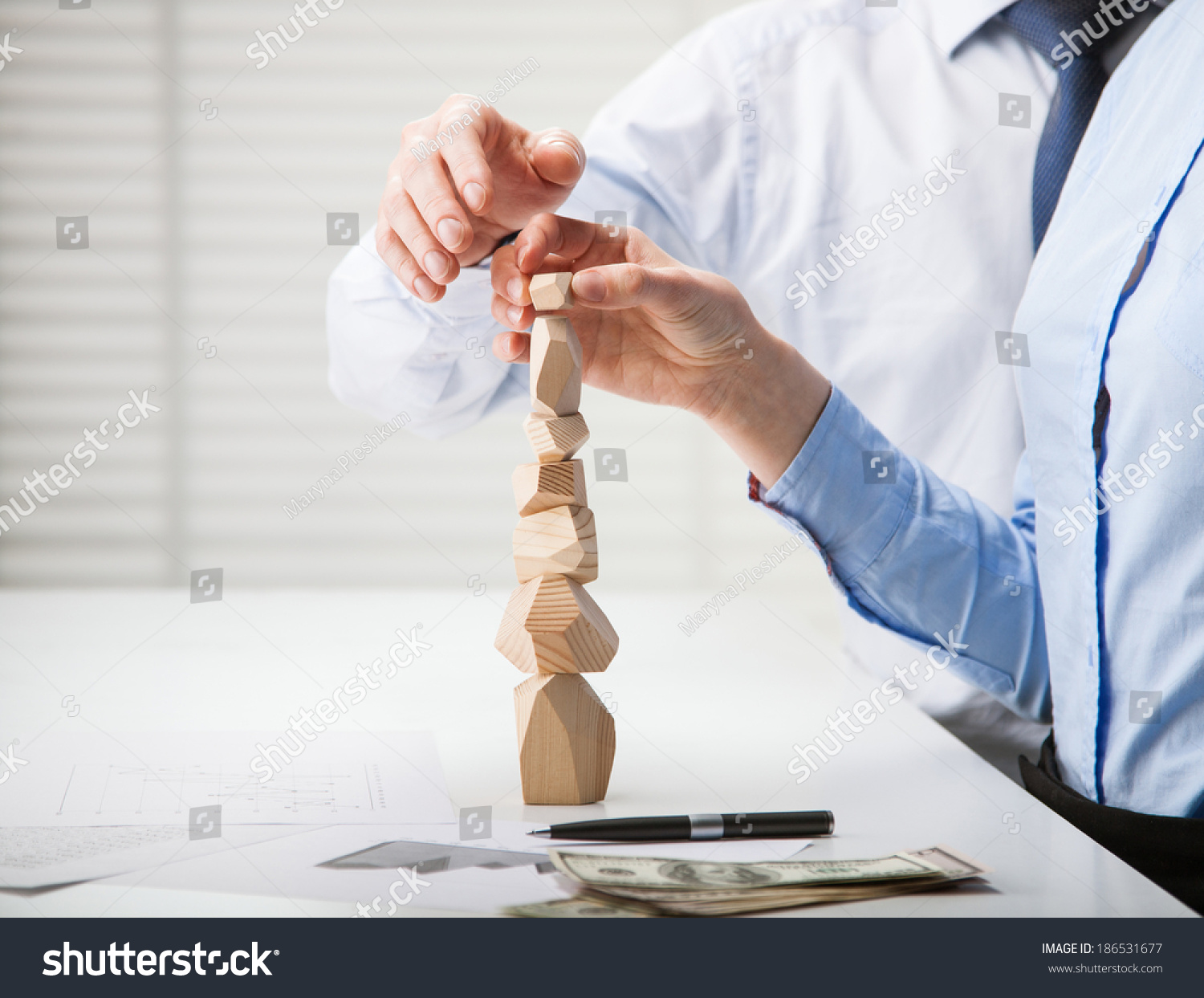 Business people building wooden tower (Japanese game tumi-ishi)  illustrating concept of business success  cooperation  achievement and self-control