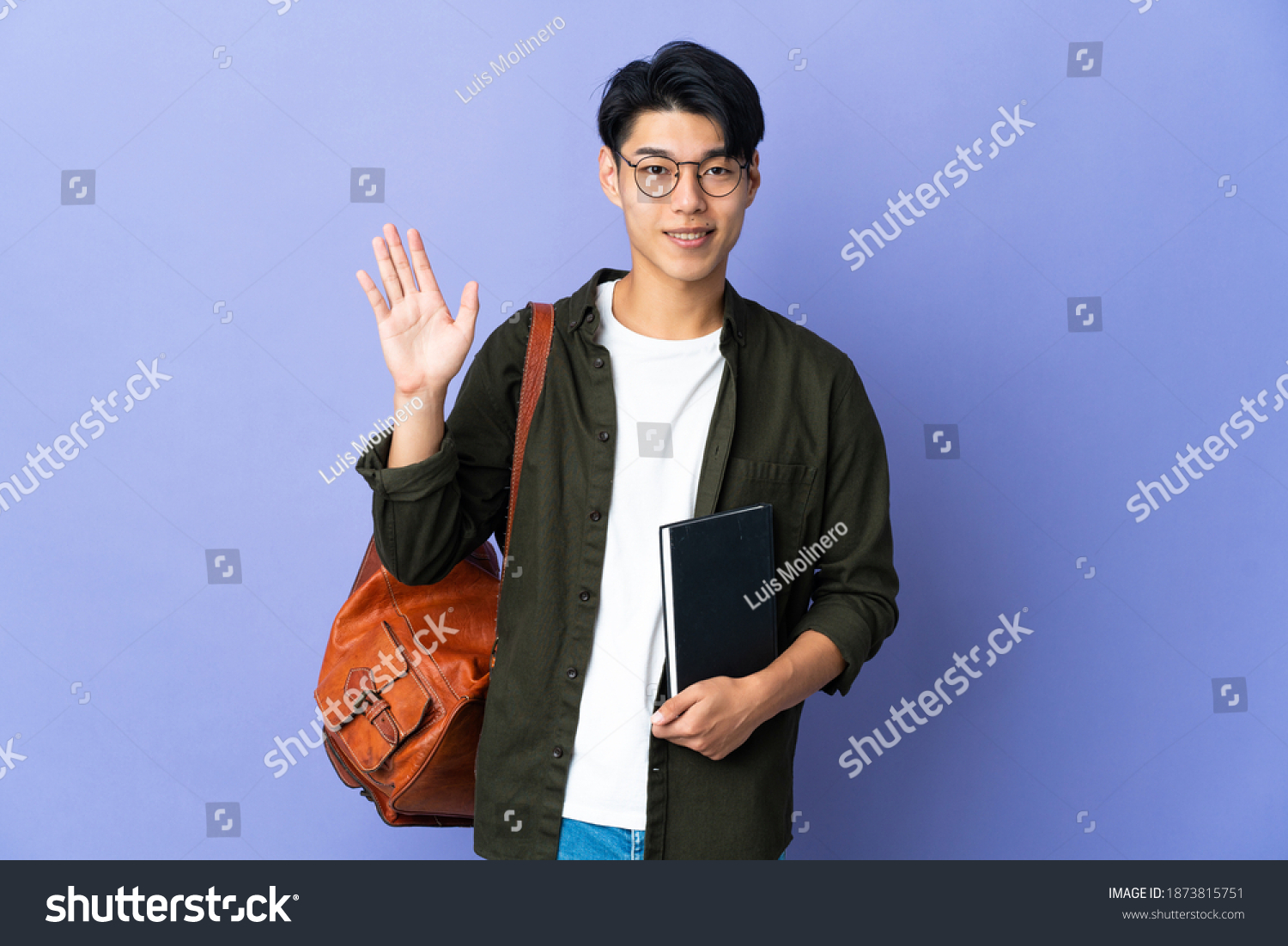 Young student woman isolated on purple background saluting with hand with happy expression