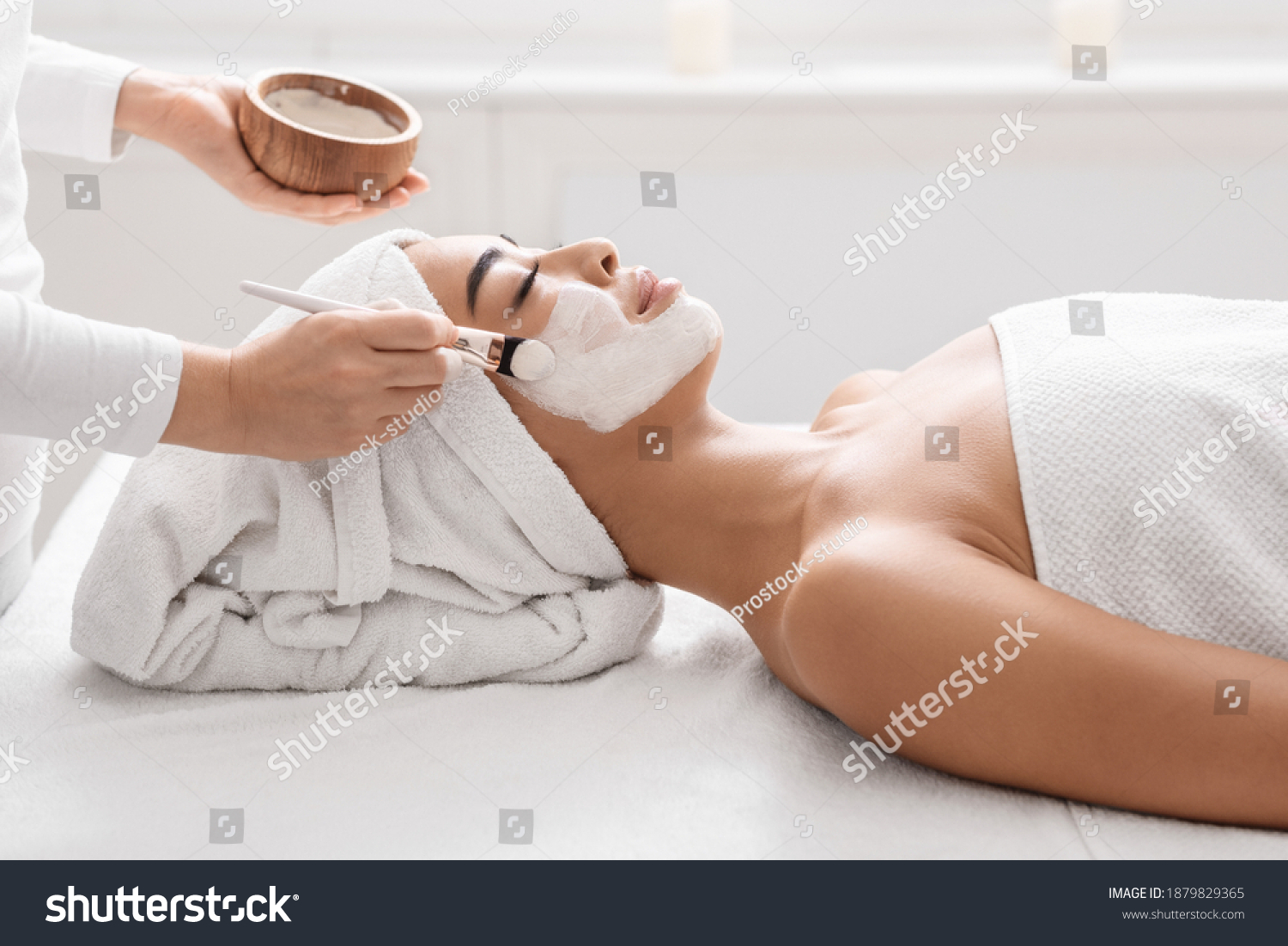 Skin Lifting Treatment. Young asian woman getting facial nourishing mask by professional beautician at spa salon calm lady enjoying wellness day and beauty procedures side view with copy space