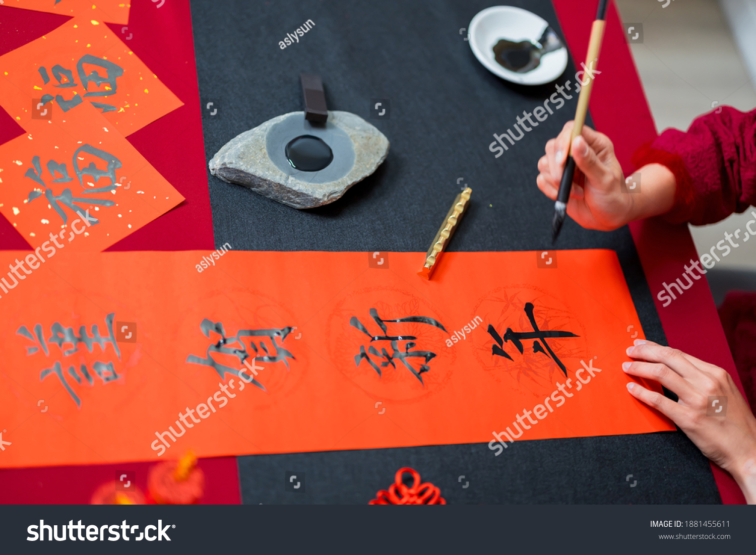 Close up of writing spring festival couplets to celebrate Chinese holidays with word meaning happy new year