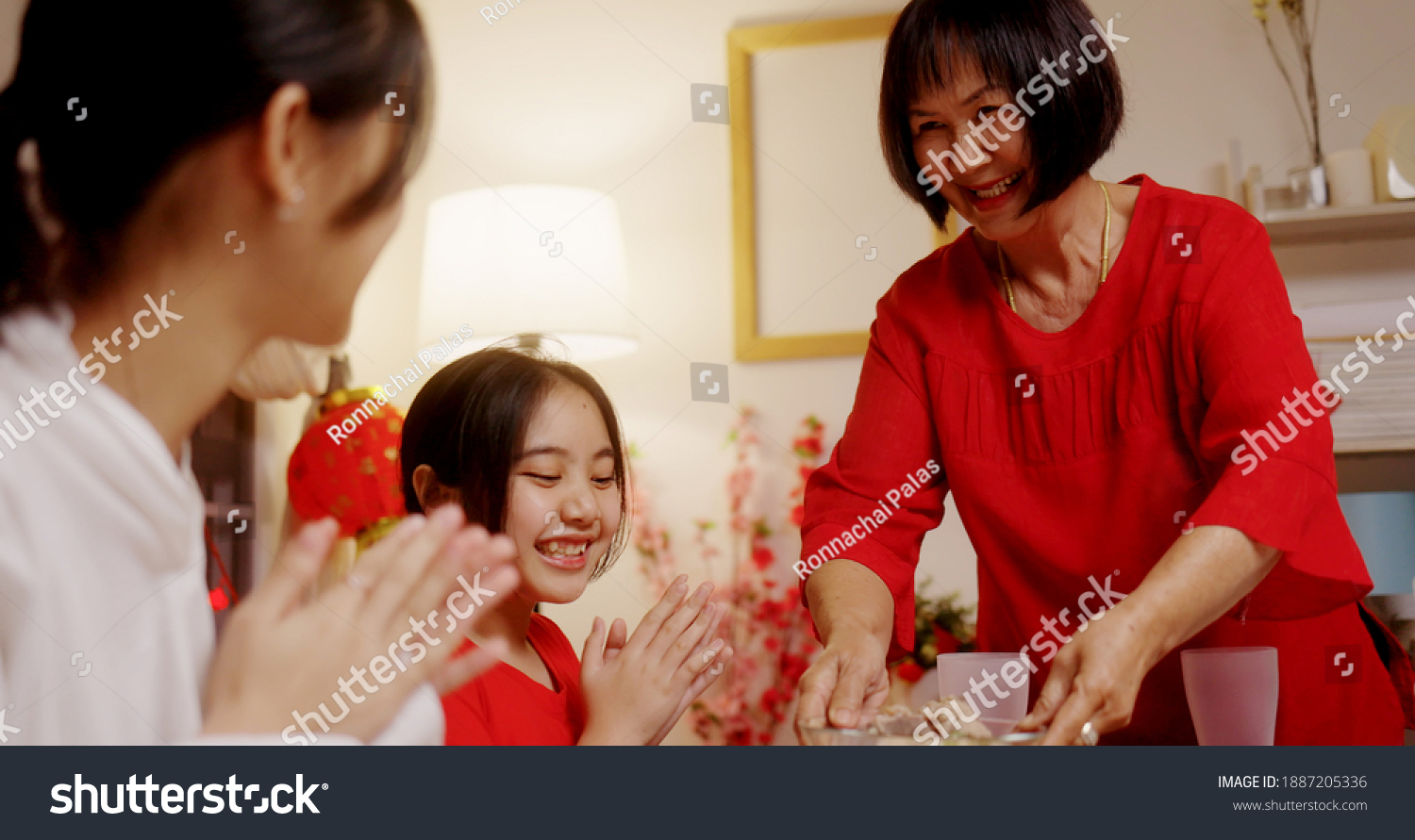 Happy Chinese Family Eating Dinner For Chinese New Year Celebrations Together At Home.