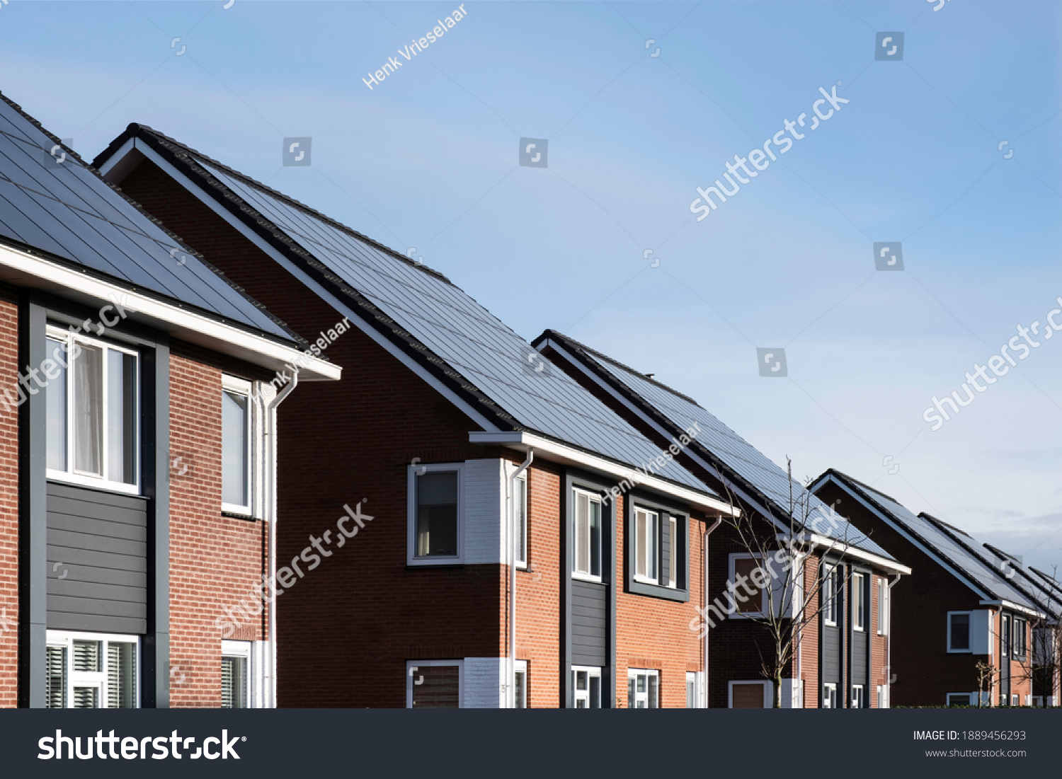 Solar panels mounted on the roofs of a row modern newbuild houses in