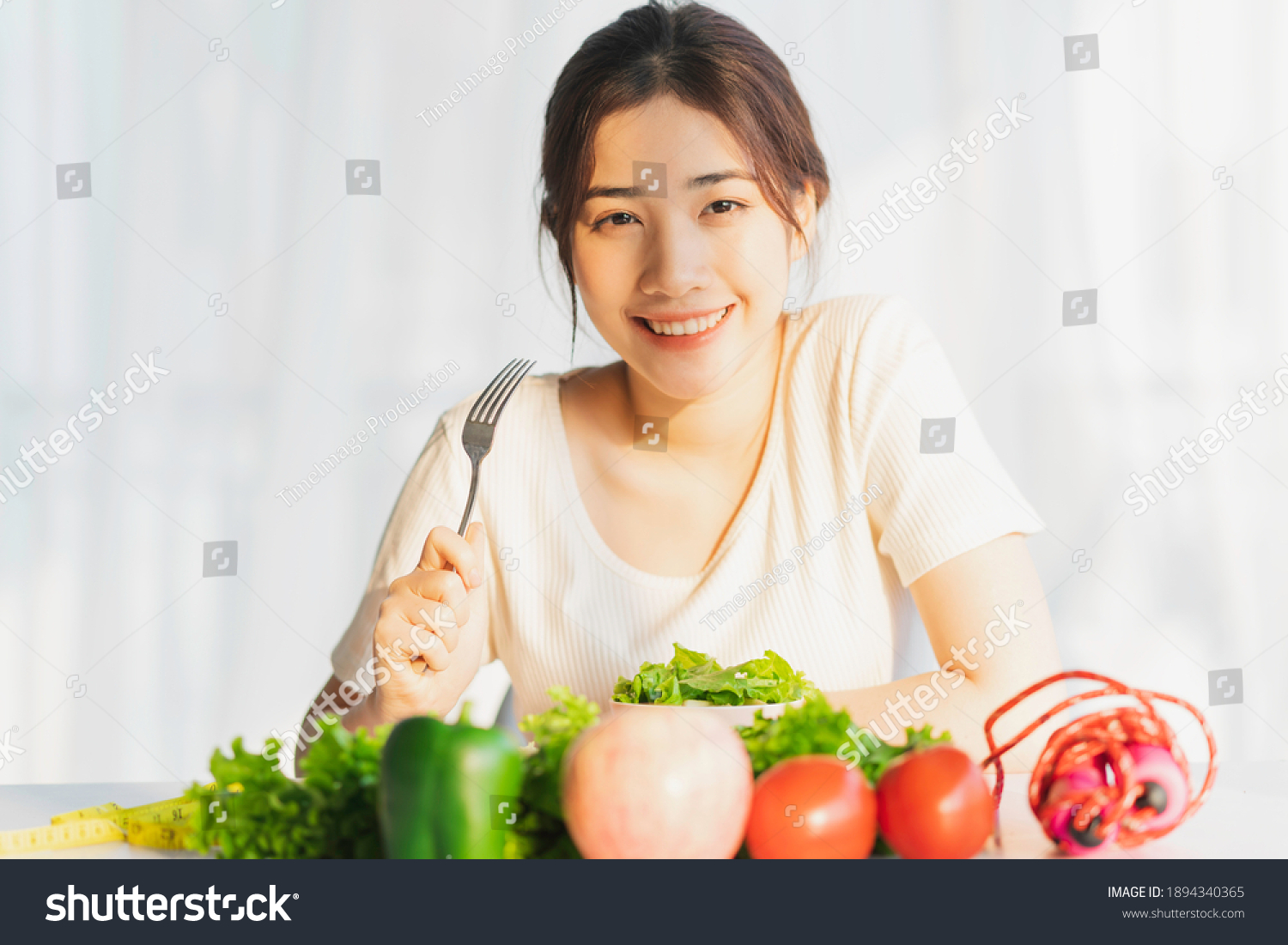 Young woman is eating green vegetables for weight loss
