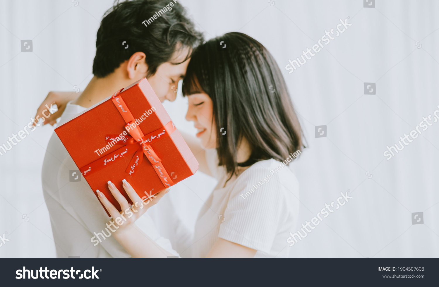 Asian boyfriend gives gifts to his girlfriend on Valentine's Day
