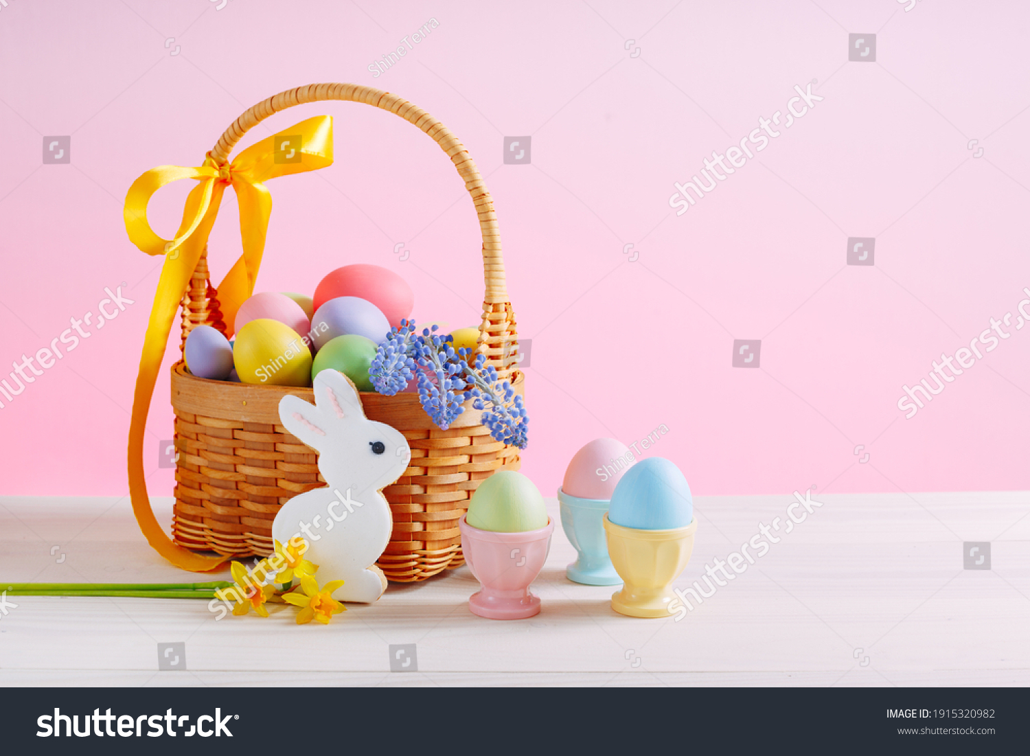Basket with flowers and decorated eggs for the Easter holiday. Colorful ...