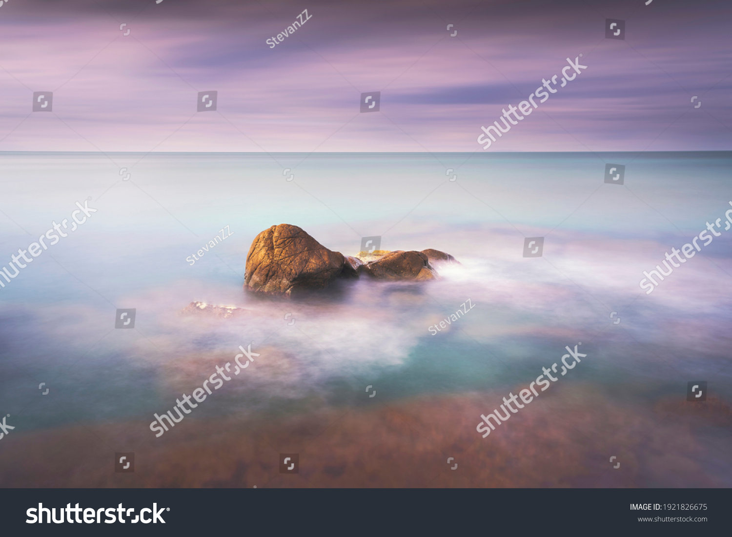 Rocks soft sea and clouds in the sky beautiful landscape in long exposure photography. Castiglioncello Tuscany Italy.