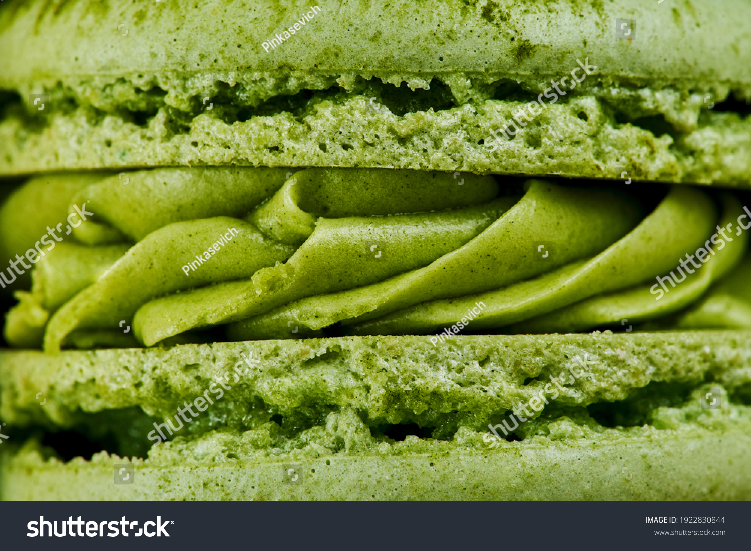 Macro plan of green French macaroons with matcha flavor. Close up of the cream filling with different toppings and fluffy cookies.