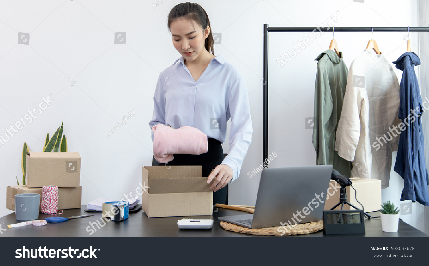 Young Asian women pack their clothes into boxes and prepare them to be delivered by post Online clothing sales business Business of selling clothes on social media or selling online.