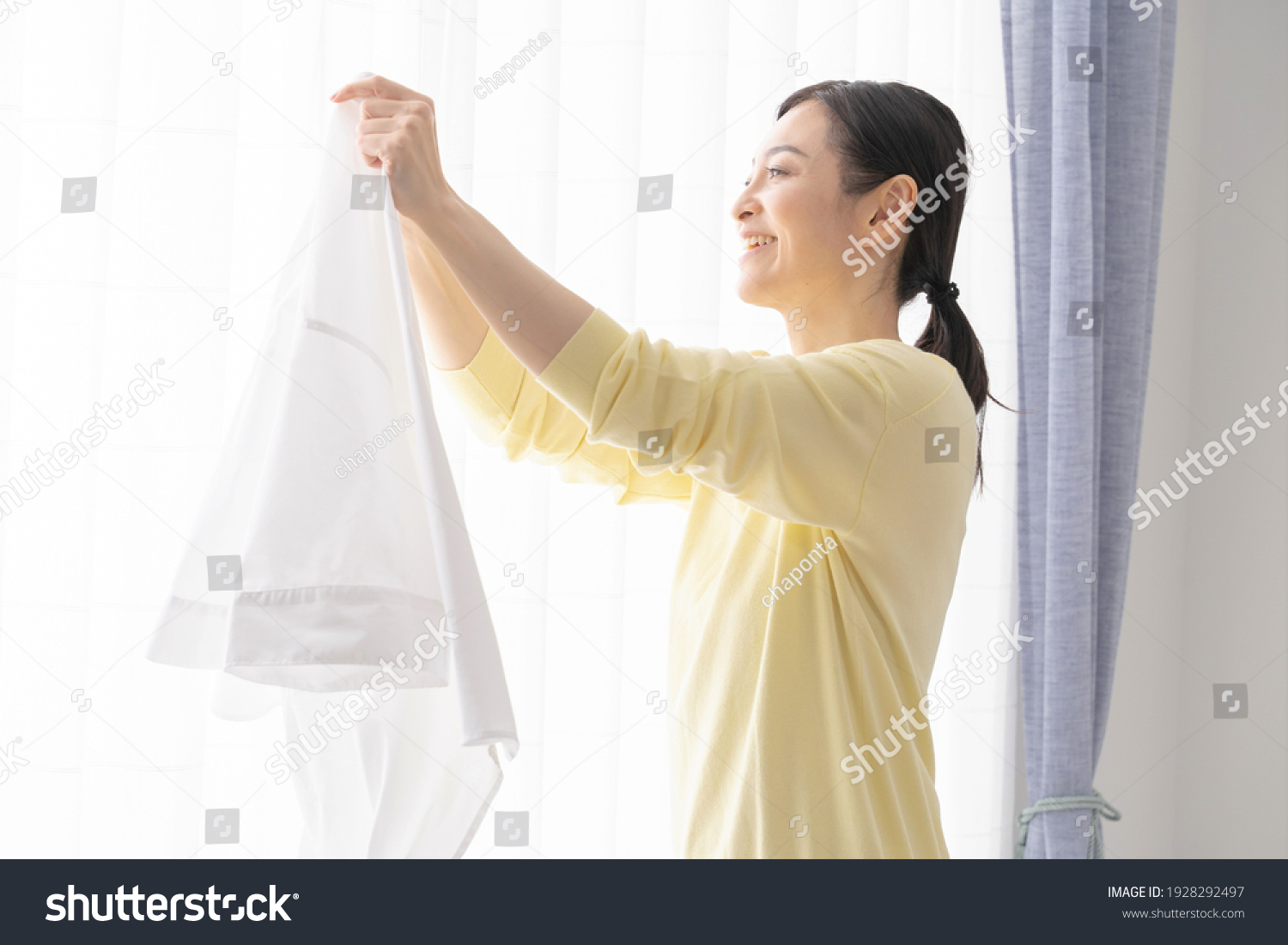 Japanese woman hanging laundry in the room