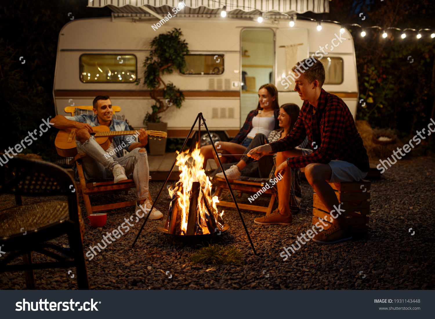 Friends playing on guitar by the campfire  camping