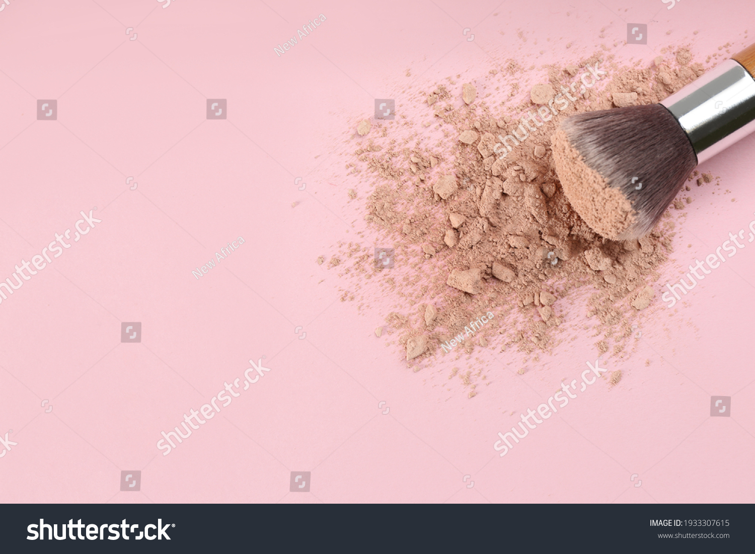 Makeup brush and scattered face powder on pink background  top view. Space for text