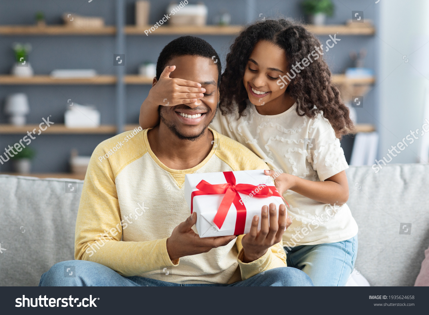 Happy little daughter giving present to her dad