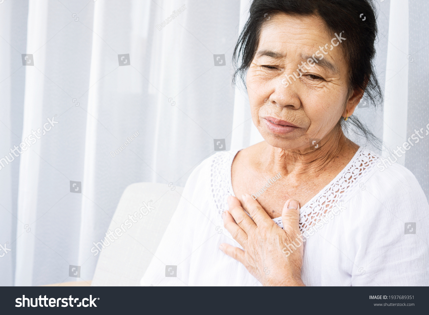 old Asian woman having problem with shortness of breath difficult breathing hand touching her chest