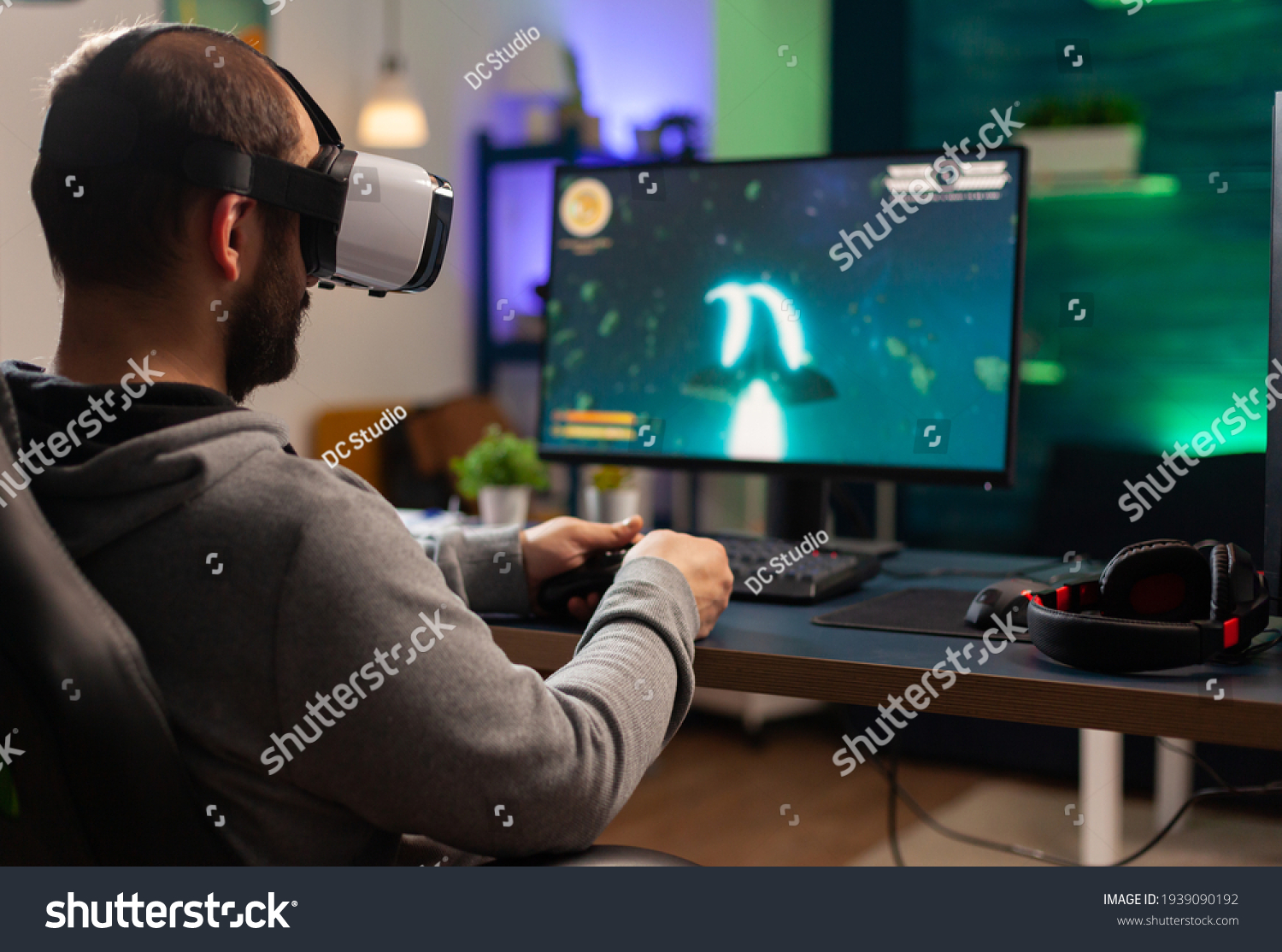 Competitive gamer playing e-sport championship using technology network wireless Professional man wearing vr headset and play online space shooter competition on powerful computer