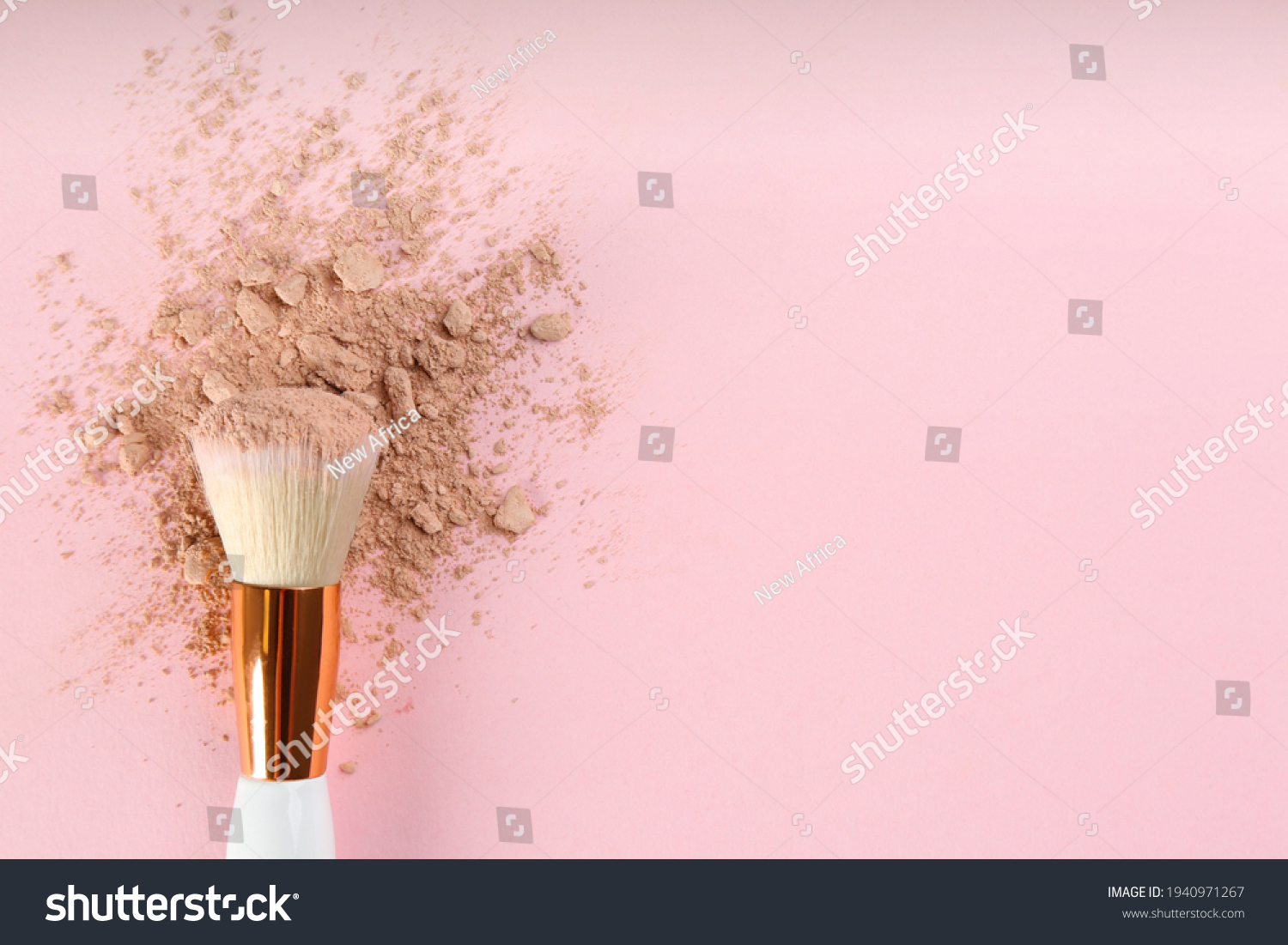 Makeup brush and scattered face powder on pink background  top view. Space for text