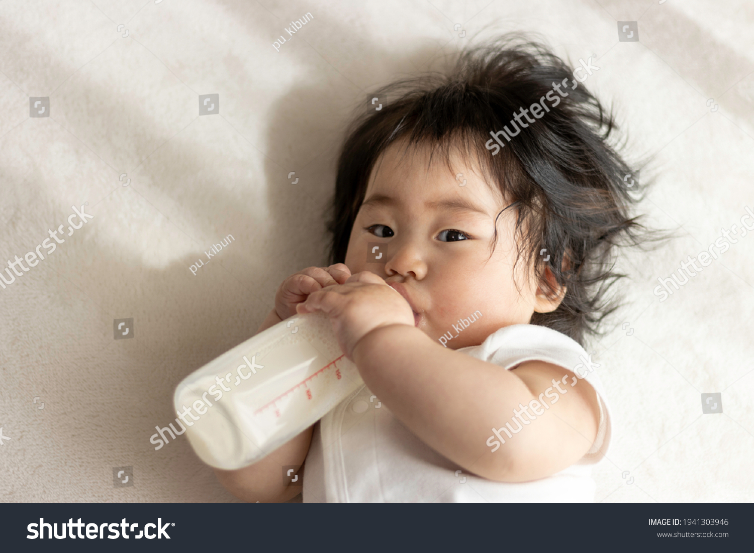 Baby drinking milk with his own baby bottle (0 years old  8 months old  Japanese  girl)