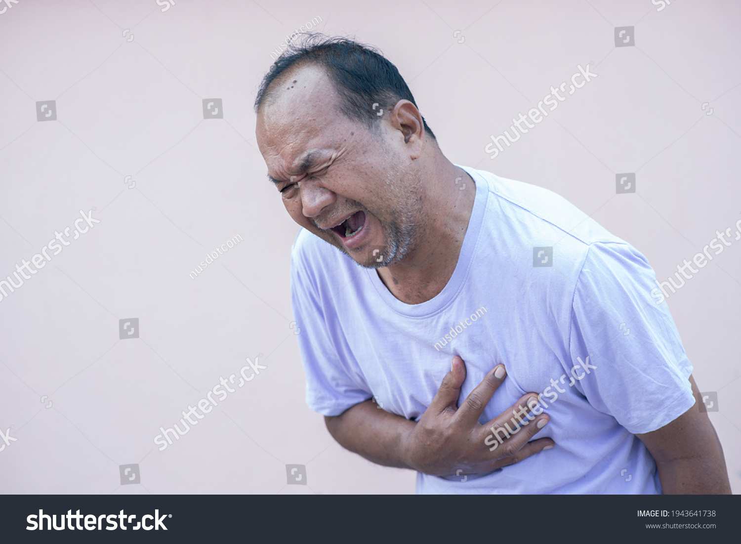 Senior male Asian  holding his heart in pain and suffering from bad pain in his chest heart attack  senior heart disease
