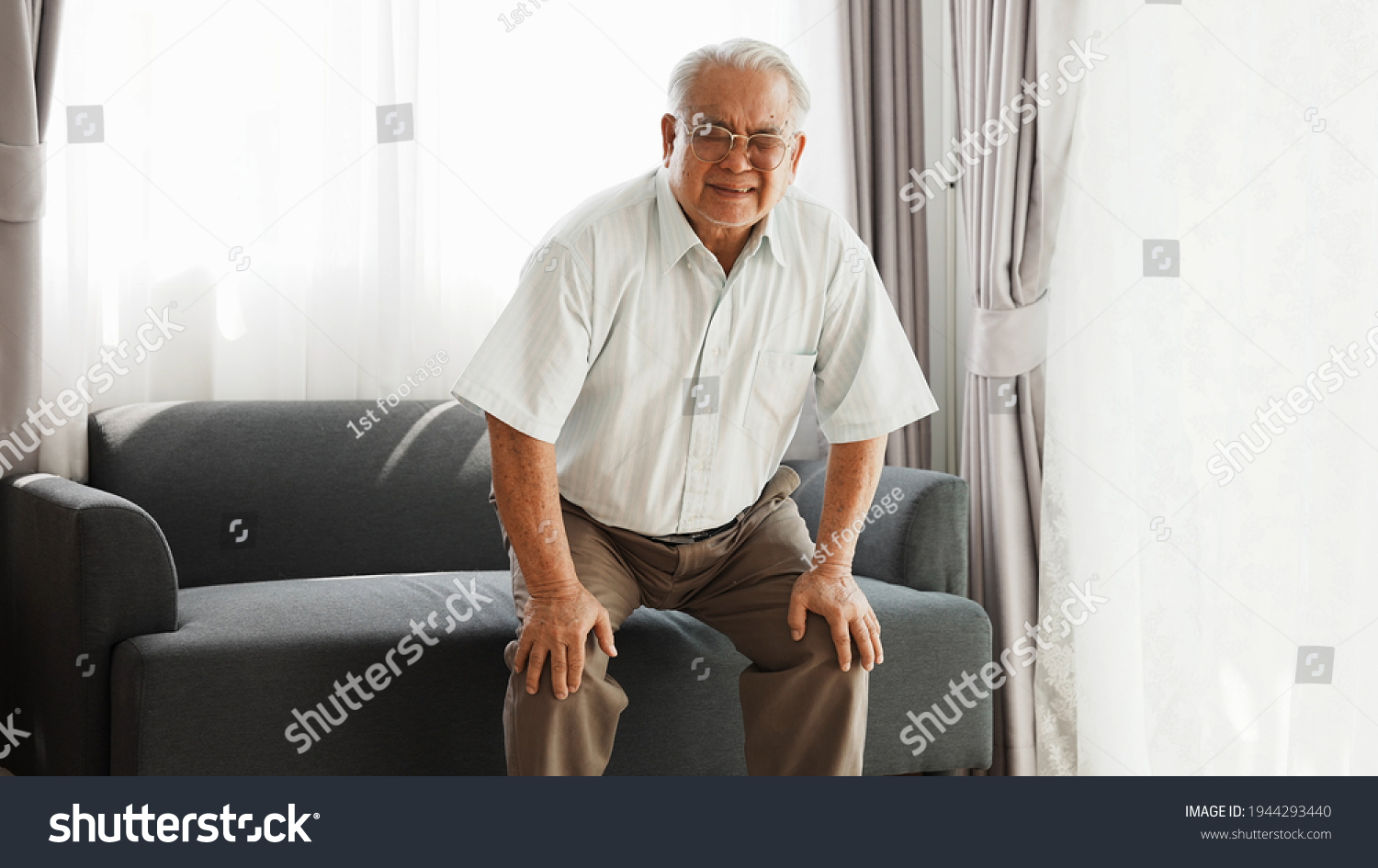 Knee problem of senior  has leg pain when standing up and sitting down during old age. Asian senior has knee pain after stand up and sit down in living room at home.