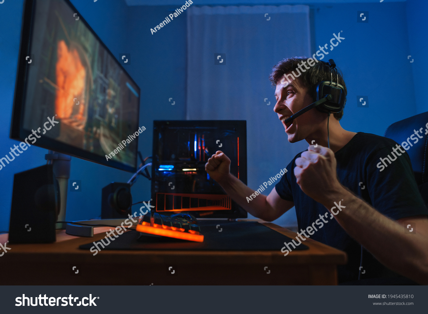 Cybersport young pro gamer happy with winning the game  feel exited  show YES hand gesture  celebrates victory in online game competition. Side view. Guy playing video game at home in his room