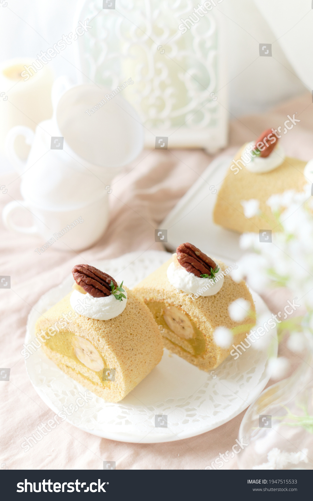 Banana Swiss Roll Cake with banana cream filling set on white cafe table.
