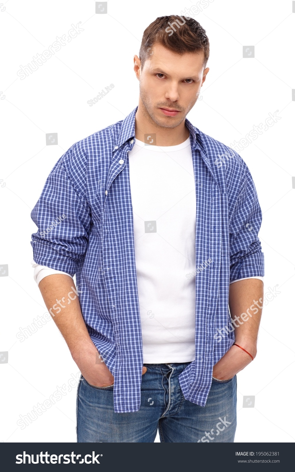 serious looking young man standing with hands in pockets