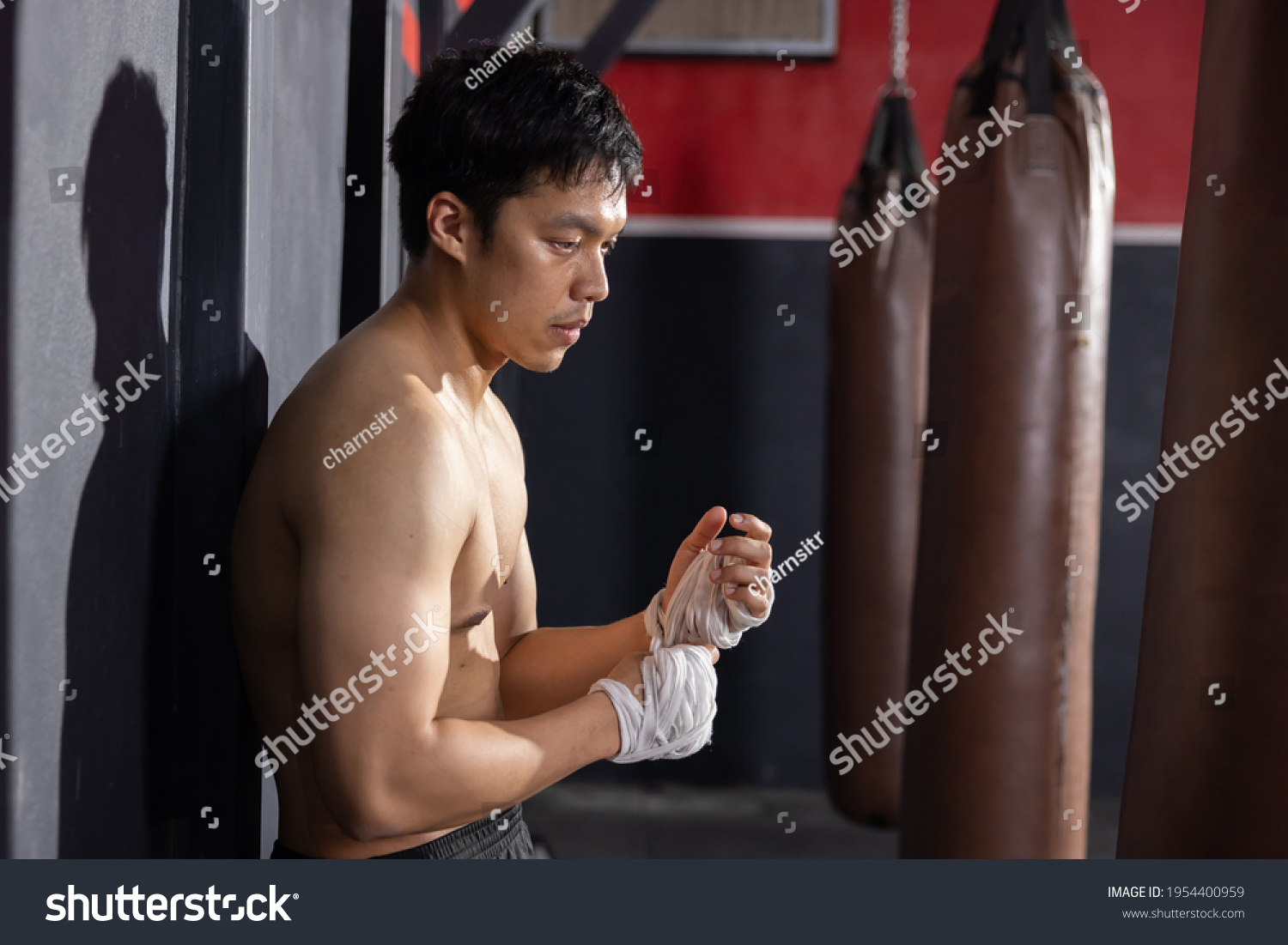 Asian Boxer Wrapping His Hands Before Thai Boxing Training